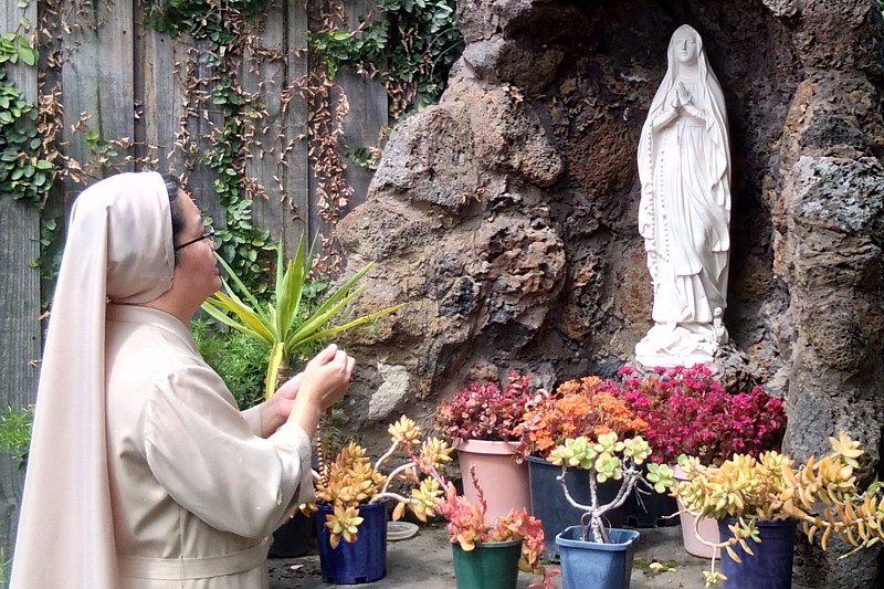 Sr Cielo with Mary grotto in the Daughters of Divine Zeal Australia garden.